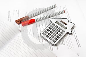 Calculator and contract - mortgage and real estate concept