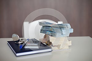 Calculator with diary, euro bills and pen, lying on a table