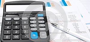 Calculator on financial papers at the table close up