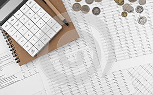 Calculator on financial statement and coins