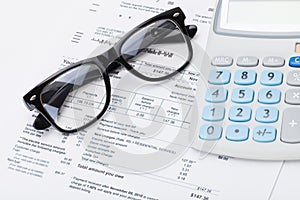 Calculator and glasses with utility bill under it - studio shot