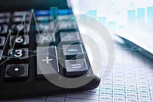 Calculator with graph stock market and pen on data document