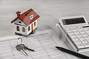 Calculator, house model, keys and documents. Real estate agent`s workplace