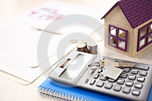 Calculator, House Model, Notebook, Key on Table