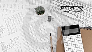 Calculator, keyboard, magnifying glass, pen, eye glasses lying on financial documents . Financial and business concept. Top view