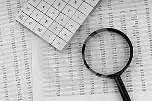 Calculator and magnifying glass on financial documents