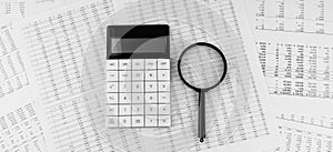 Calculator and magnifying glass on financial statement. Financial, accounting and business concept