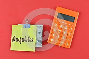 Calculator, money banknote and memo note written with PAYABLES