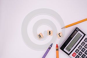 Calculator next to school items laying flat on white background