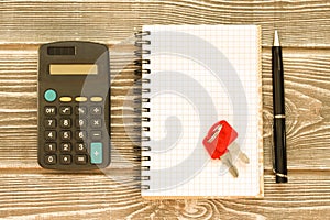 Calculator, notebook, keys, pen on the background