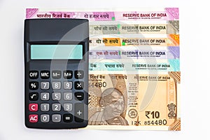 Calculator over brand new indian 10, 50, 100, 200, 500 and 2000 rupees banknotes. Colorful money background