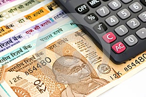 Calculator over brand new indian 10, 50, 100, 200, 500 and 2000 rupees banknotes. Colorful money background