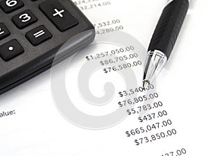 Calculator and pen with balance sheet