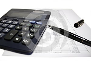 Calculator and pen on balance sheet