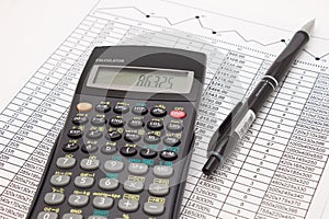 Calculator and pen on cash financial spreadsheet