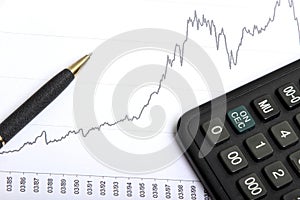 Calculator and pen on the chart of the stock exchange