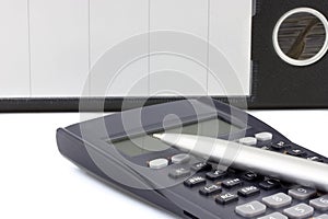 Calculator with pen and dossier on the background