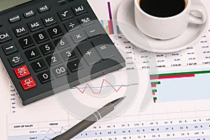 Calculator, pen and financial indicators close-up. Desk of a businessman. Statistics and monitoring the stock market.