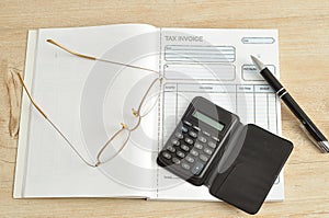 Calculator, pen, glasses and invoice book