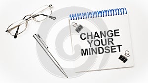 calculator, pen, glasses and notepad with text CHANGE YOUR MINDSET