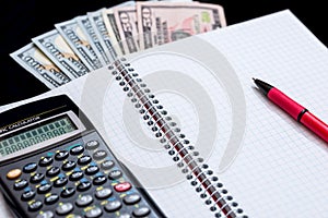 Calculator, pen, notebook and money