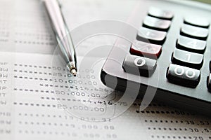Calculator and pen on saving account passbook or financial statement