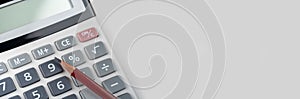 Calculator with pencil on grey background. Business report concept. wide banner, copy space. Close up of calculator and red pencil