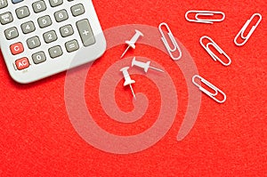 A calculator, pushpins and paperclips