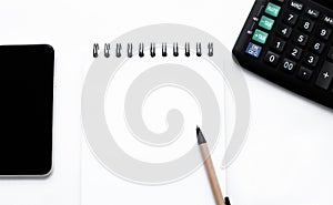 Calculator, smartphone, notepad, pen on the white background top view