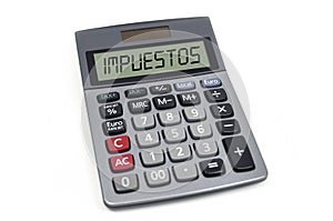 Calculator with the spanish word for tax - impuestos isolated photo