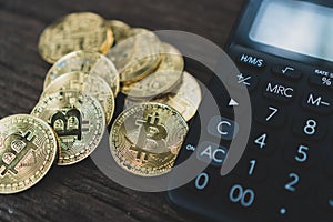 Calculator and a stack of Bitcoins coins as symbol of cryptocurrency digital money in the future blockchain