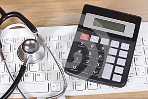 Calculator and stethoscope on a computer keyboard