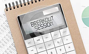 Calculator with text breakout session with craft colored notepad pen and financial documents