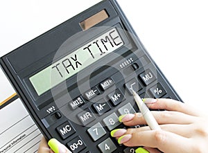 A calculator with text Tax Time on the display