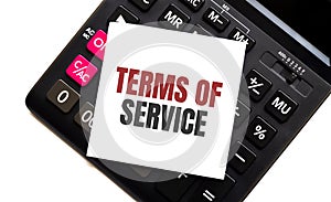 Calculator with text TERMS OF SERVICE with white paper
