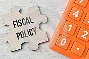 Calculator and wooden puzzle with text FISCAL POLICY