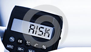 Calculator with the word risk on the display. Investment business concept
