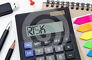 Calculator with the word risk on the display. Money, finance and business concept