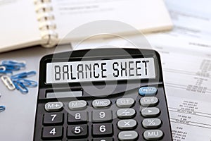 Calculator with the words BALANCE SHEET on the display