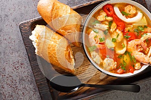 Caldeirada de frutos do mar Portuguese seafood stew with potatoes, peppers, tomatoes and onions close-up in a bowl. horizontal top photo