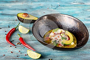 Caldo De Mariscos Recipe seafood soup with fish, vegetables and avocado close-up in a bowl on the table. photo