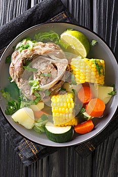 Caldo de Res is a Mexican beef soup with lots of vegetables such as squash, corn, carrots, cabbage and potatoes closeup on the