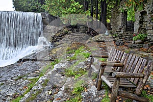 An empty bench at the tourist resort with a waterfall in Caledon, Ontario, Canada photo