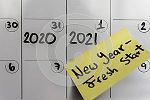Calendar with 2020-2021 date and new years resolution written on a sticky note