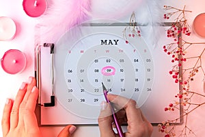 Calendar 9th of May date. Candles flowers feather. Happy Mothers day. Planning holiday. Flat lay. Top view