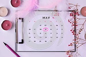 Calendar 9th of May date. Candles flowers feather. Happy Mothers day. Planning holiday. Flat lay. Top view.