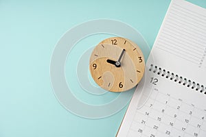 Calendar and alarm clock on the green table background, planning for business meeting or travel planning concept