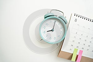 calendar and alarm clock on the white table background, planning for business meeting or travel planning concept