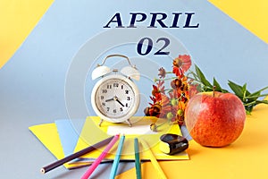 Calendar for April 2: name of the month April in Russian, numbers 02, school supplies, red apple, flowers, alarm clock on a blue