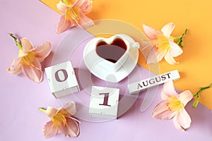 Calendar for August 1 :the name of the month of August in English, cubes with the number 01, a cup of tea in the shape of a heart